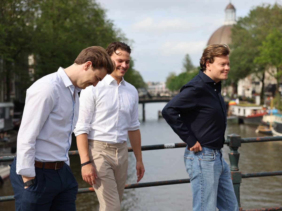 De founders van Struon wandelen lachend over een Amsterdamse brug